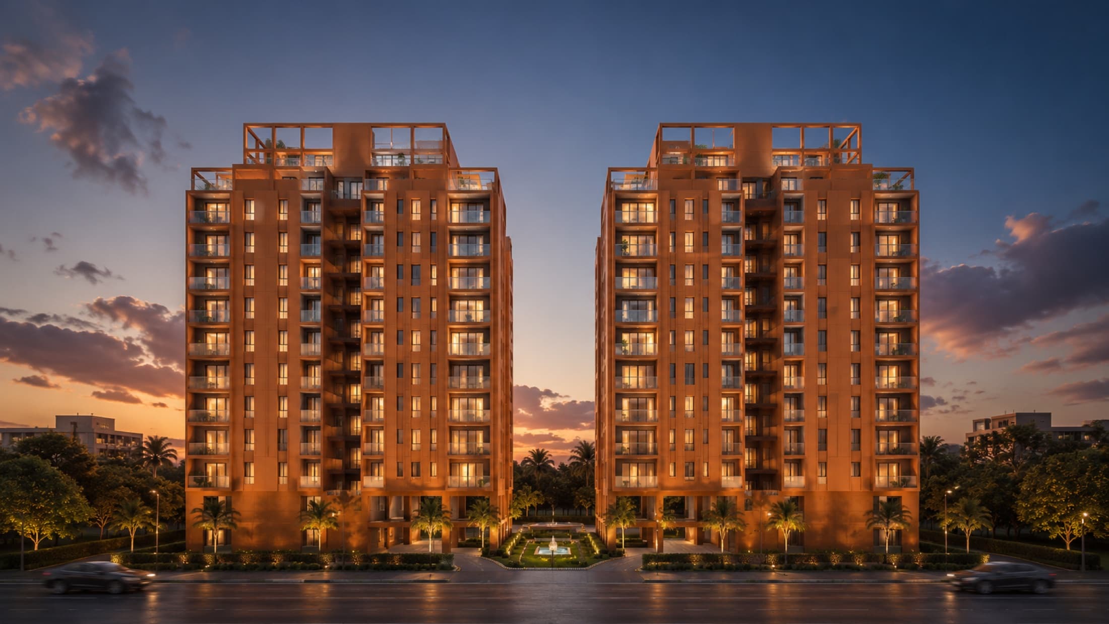 The two residential blocks at dusk, the landscaped walkway leading to the lit entrance
